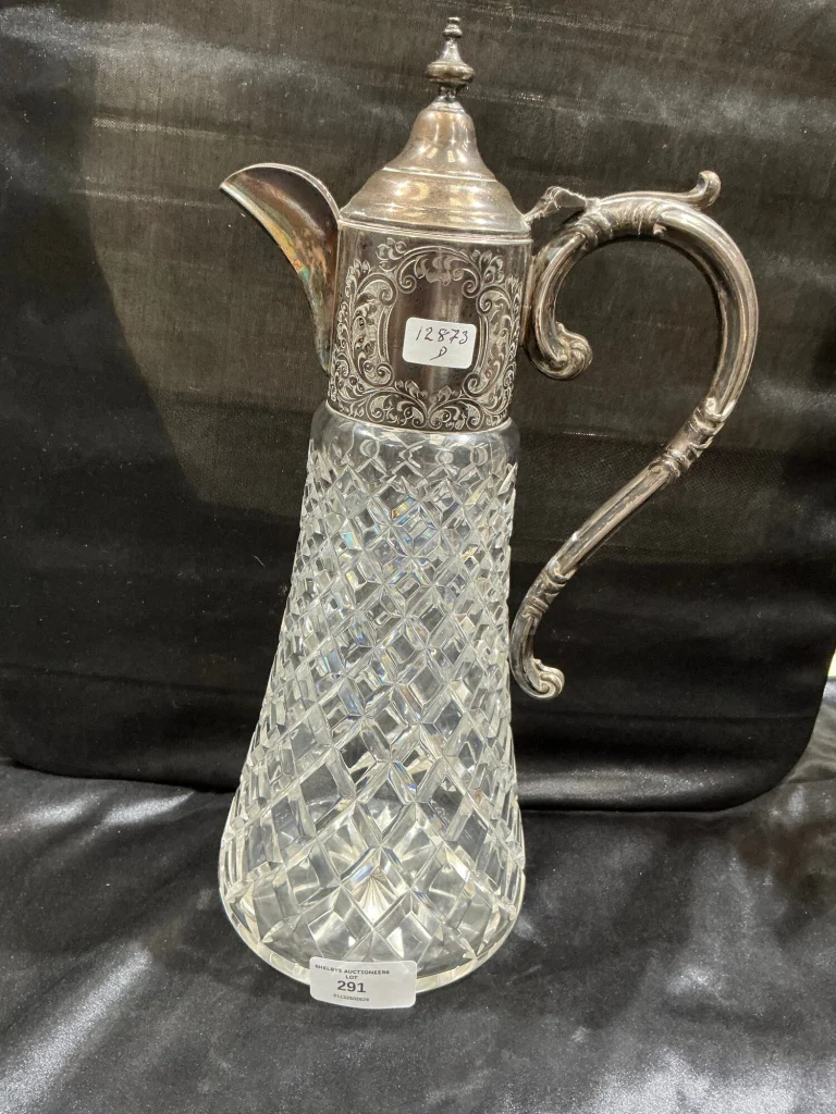 A 1970s silver-mounted cut-glass claret jug on black satin, photographed for a Shelbys sale